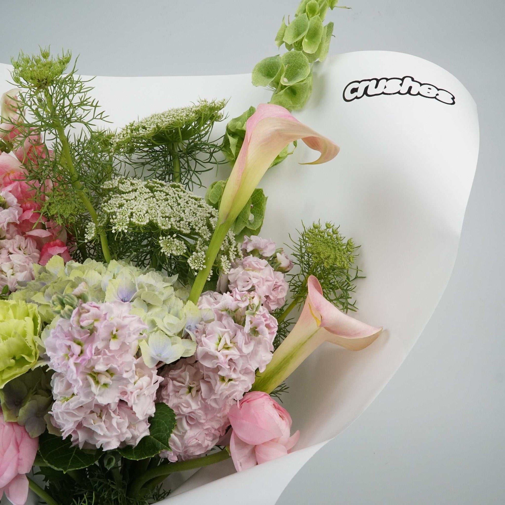 The No.06 - Pastel Crush bouquet with hydrangea, calla lily, dahlia, ranunculus, carnations, and fluffy stock in pastel tones.