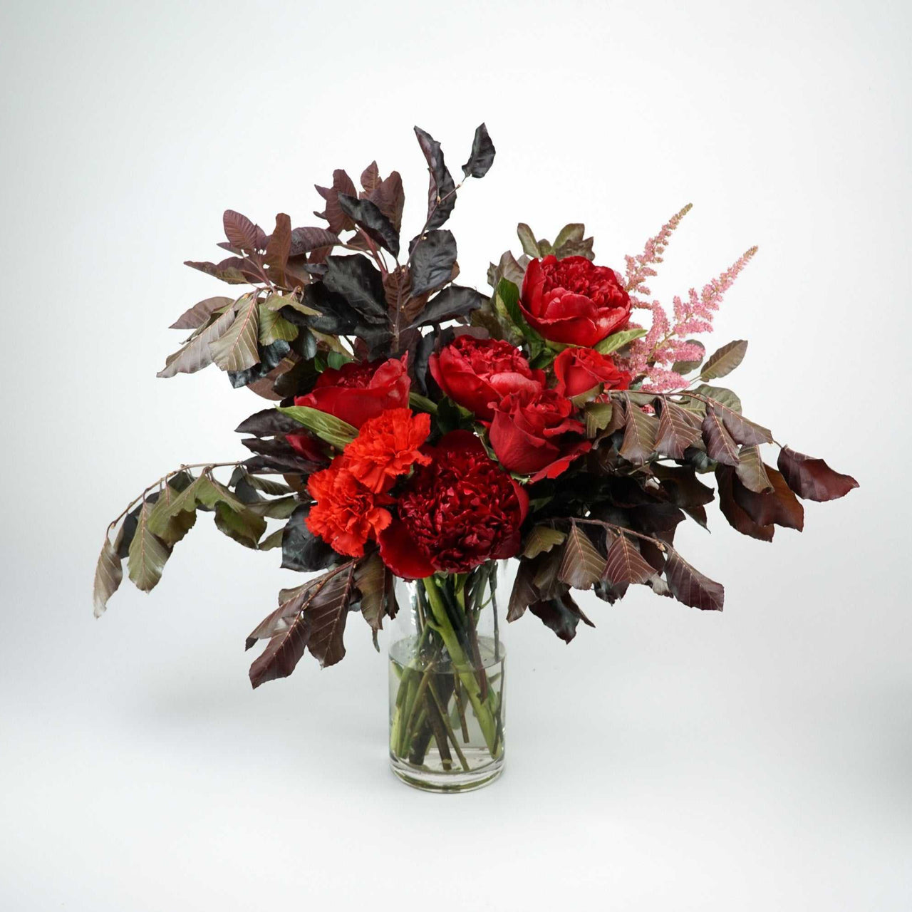 The No.05 - Elegant Flowers floral arrangement with dark foliage, peonies, roses, and carnations in rich colors.