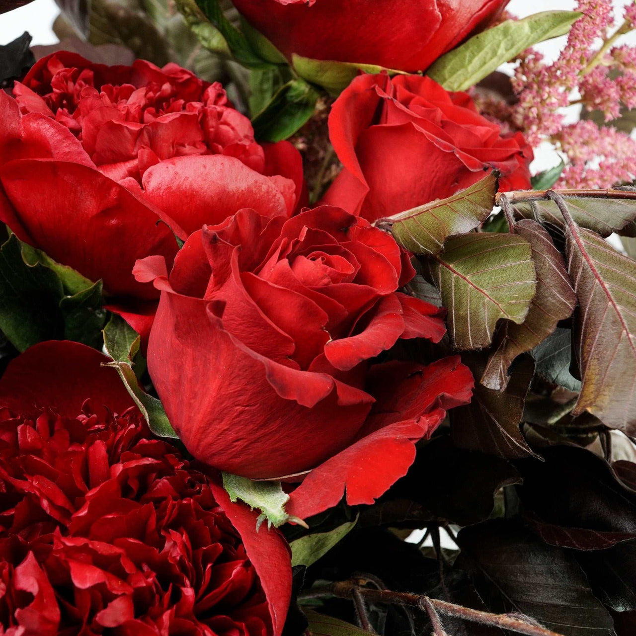 The No.05 - Elegant Flowers floral arrangement with dark foliage, peonies, roses, and carnations in rich colors.