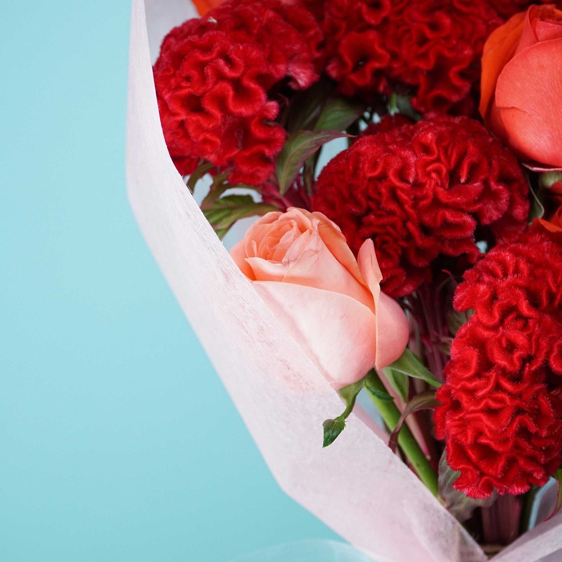 Roses With a Twist bouquet with varied roses and red velvety celosia, medium size.