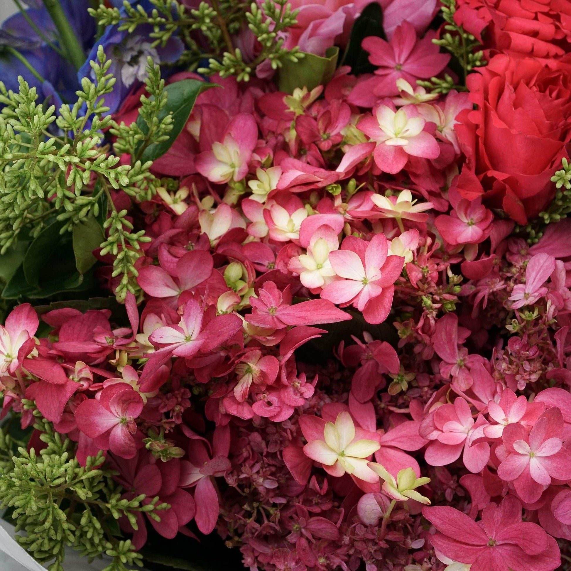 Extra large floral arrangement with pink hydrangeas, red roses, and mixed seasonal flowers. Extra Large Crush