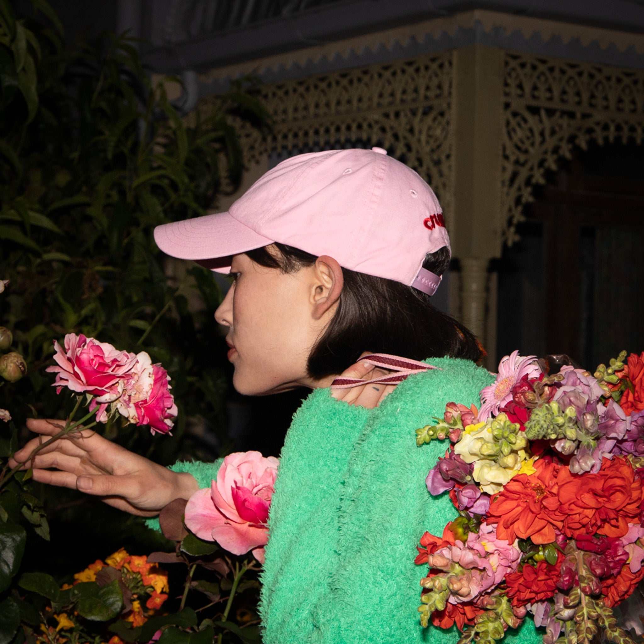 Crushes Pixel Rose Pink Cotton Cap with embroidered design, adjustable fit, worn by person in garden setting.