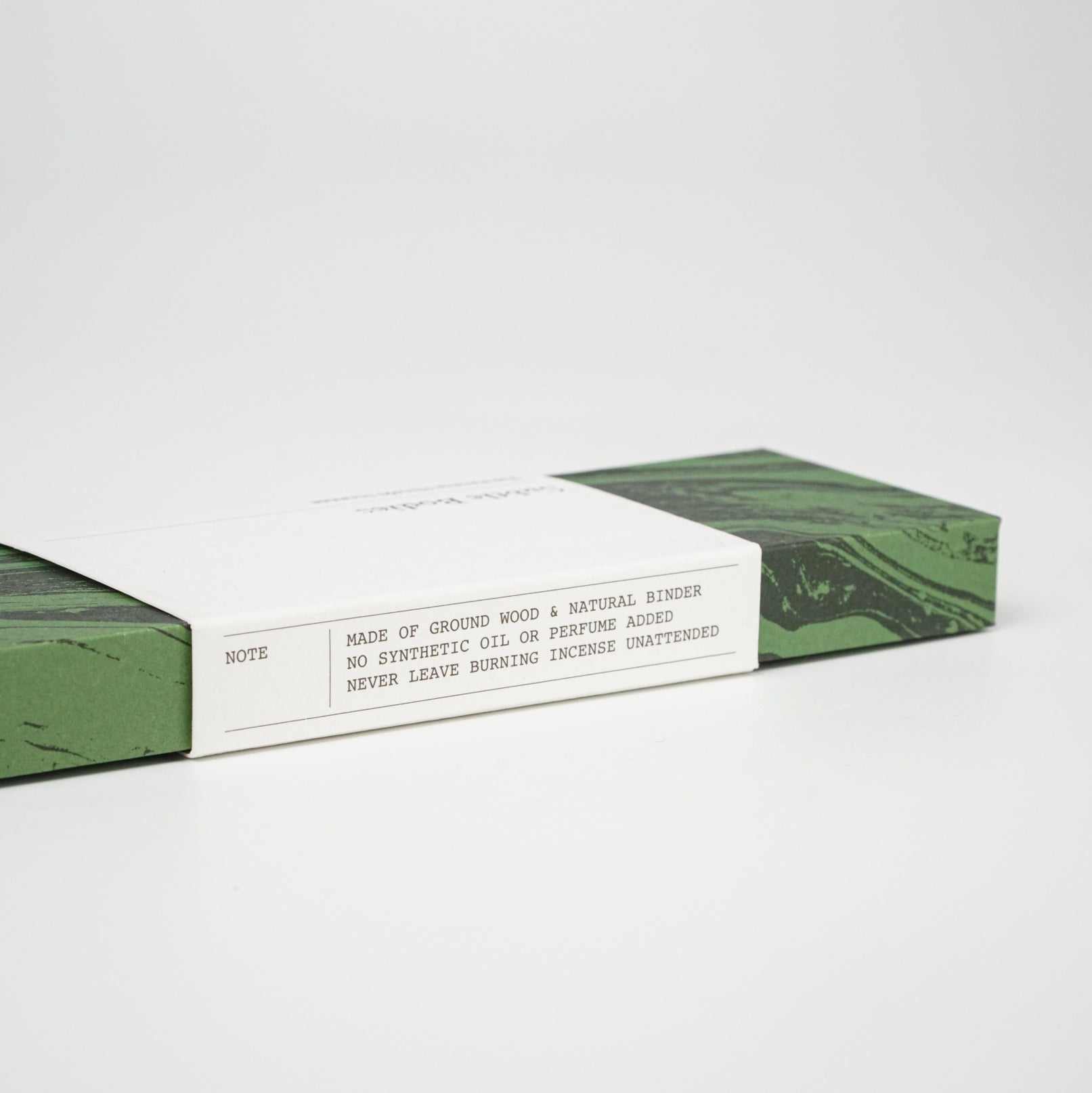 Packaging for Thai Hinoki Incense with a description highlighting natural wood and no added perfumes, set against a green design.