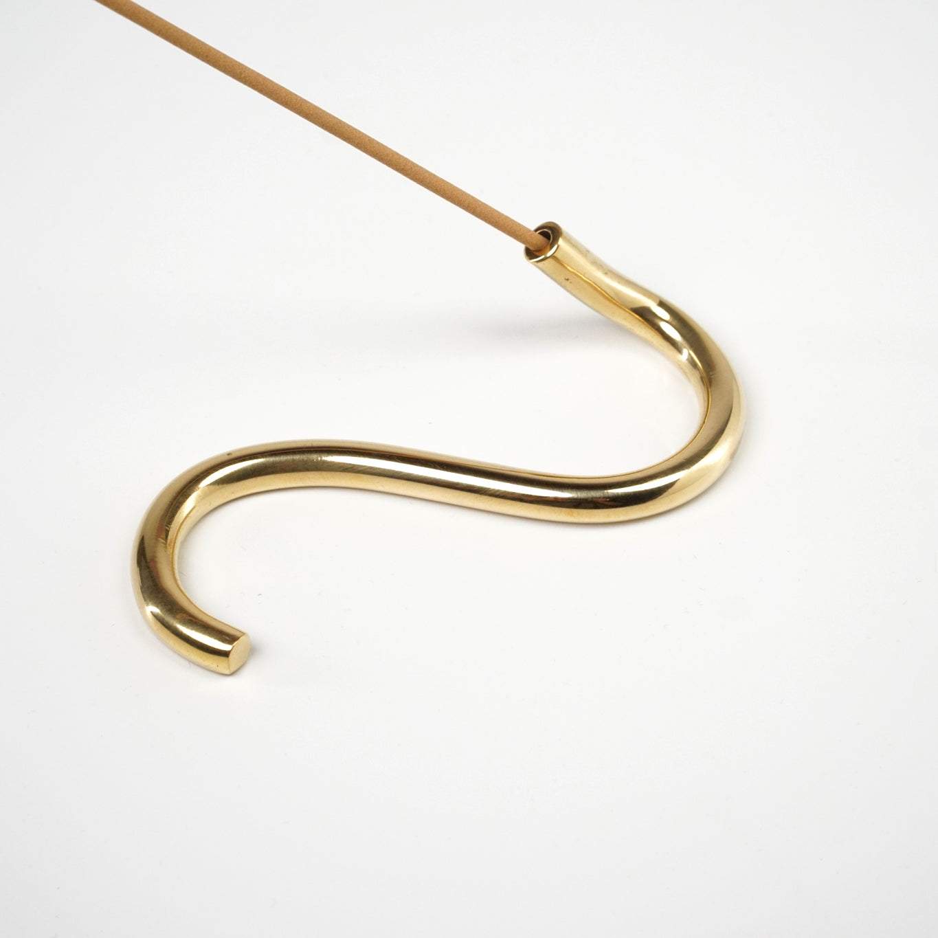 Handcrafted brass incense holder in snake shape from Northern India.