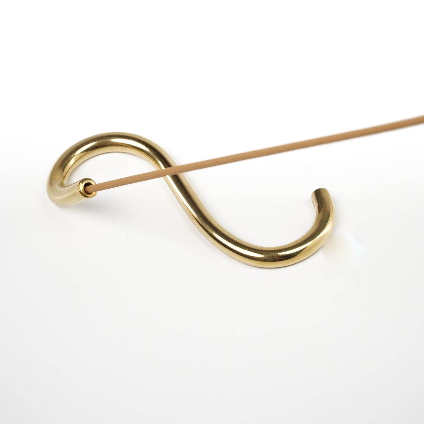 Handcrafted brass incense holder designed in a snake shape from Northern India.