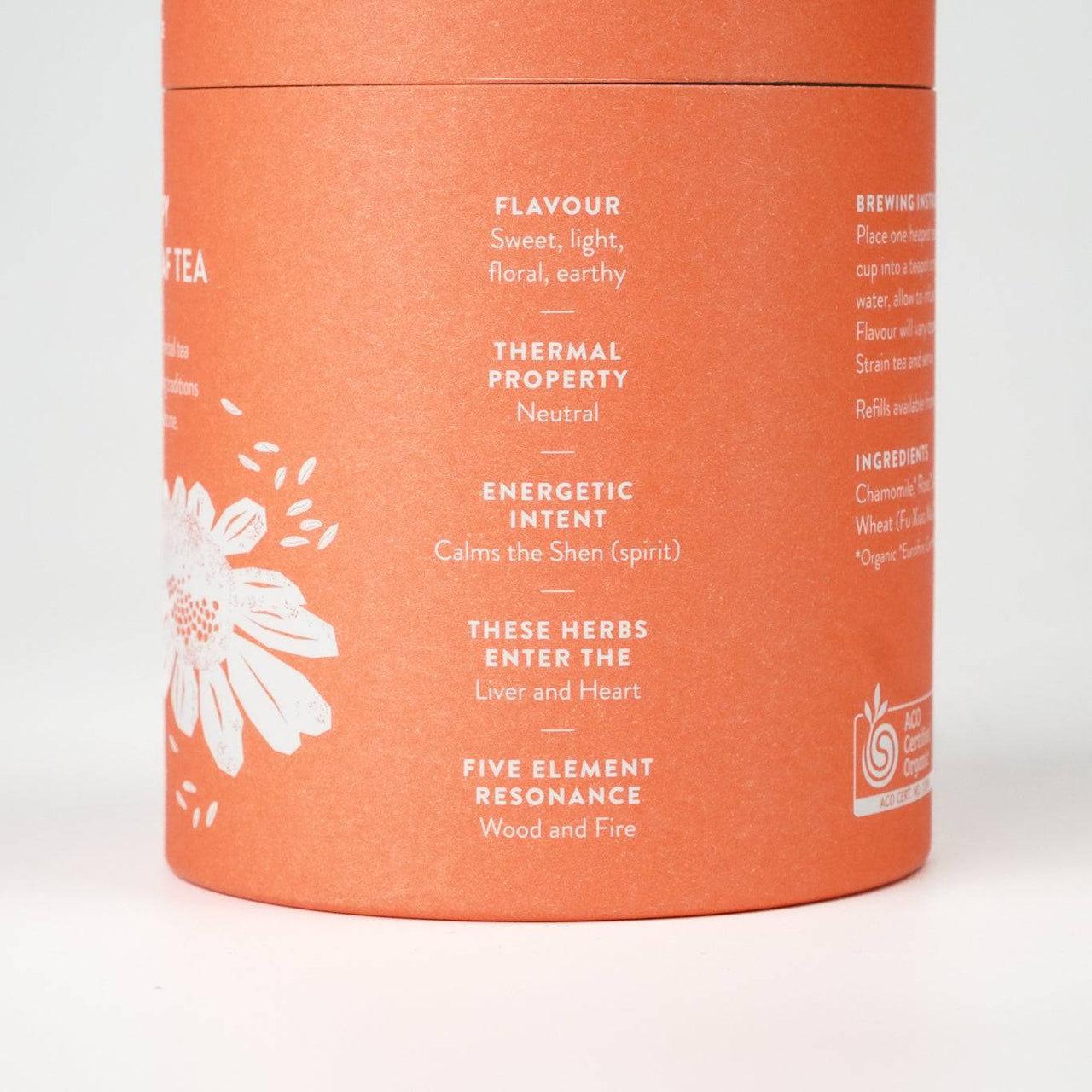 Orange cylindrical packaging of "Happy Tea" loose leaf blend with floral design.