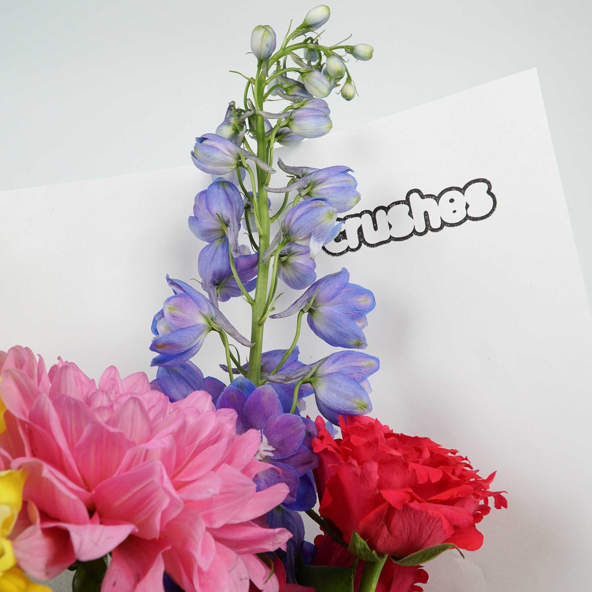 The No.04 - Colour Crush bouquet featuring vibrant seasonal flowers including delphinium, roses, and dahlias.