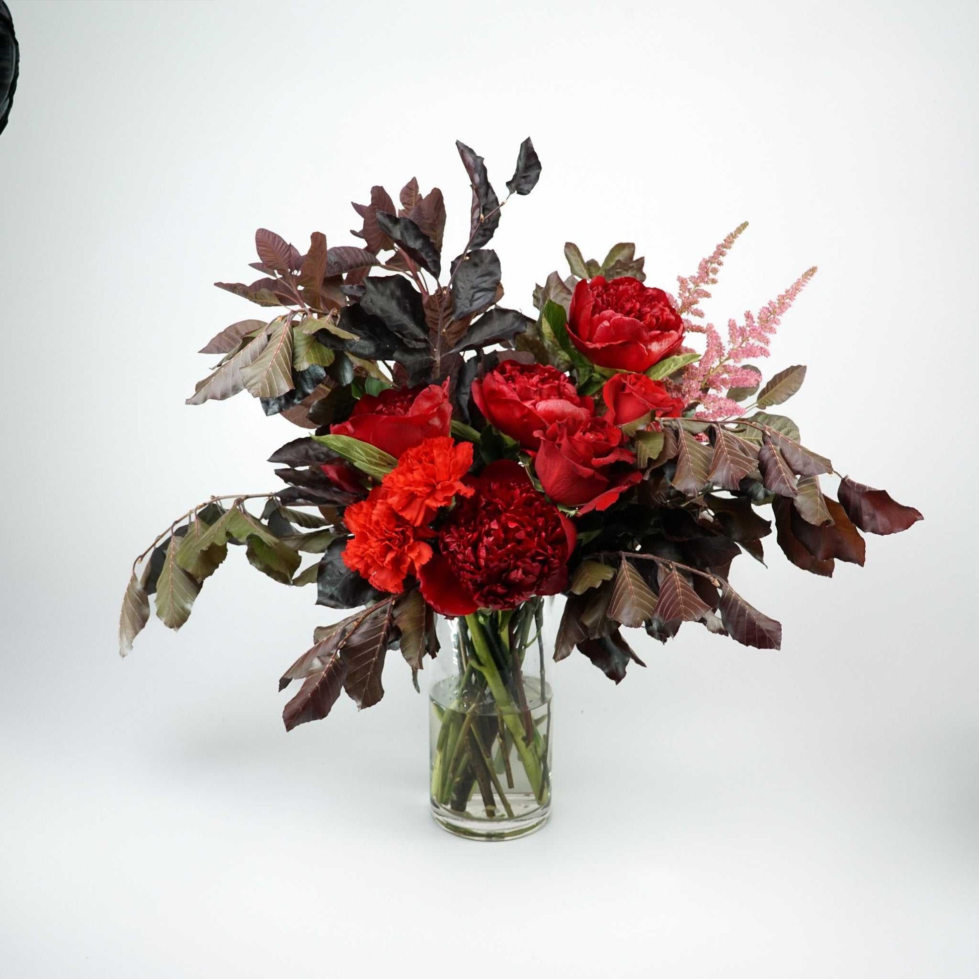 The No.05 - Elegant Flowers floral arrangement with dark foliage, peonies, roses, and carnations in rich colors.