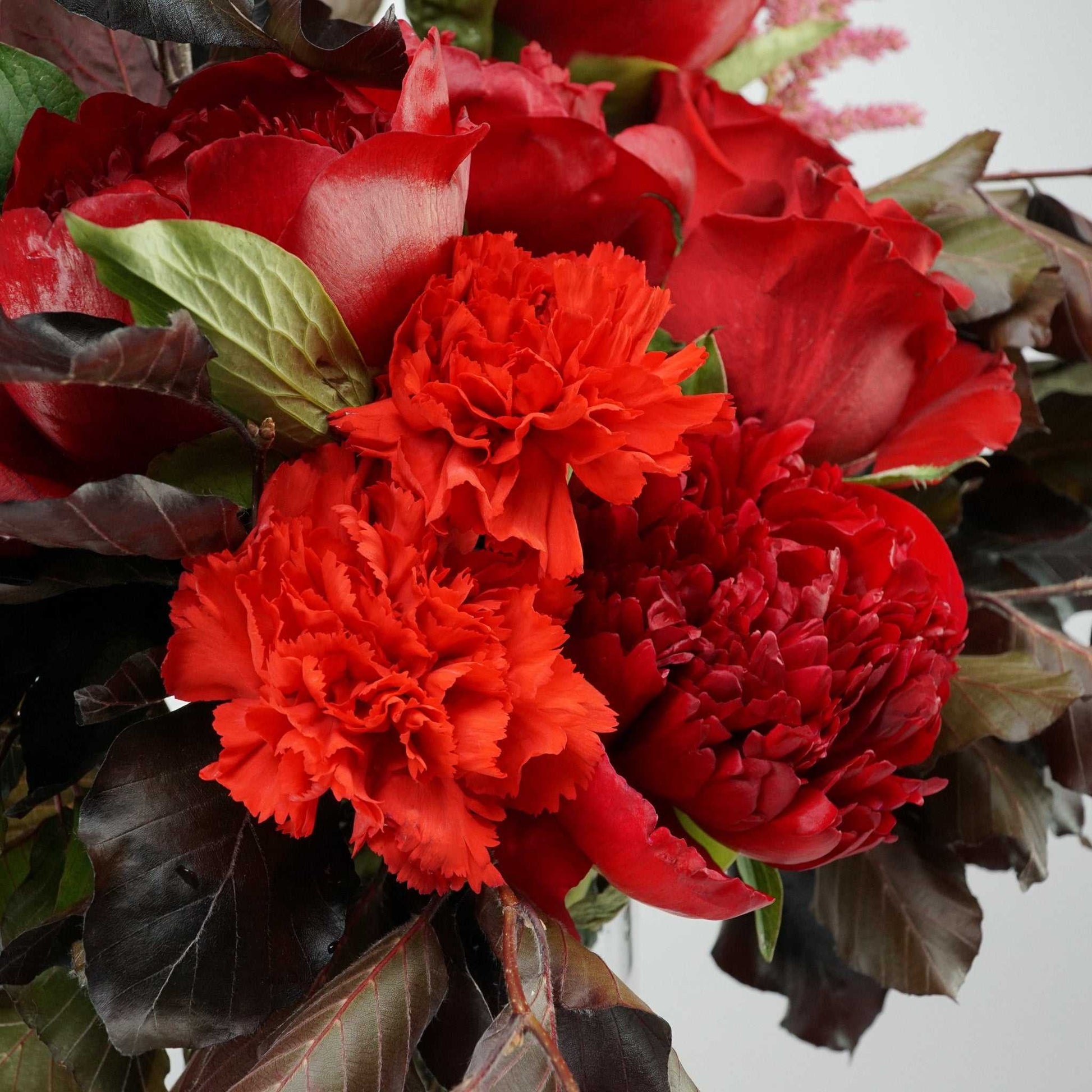 The No.05 Elegant Flowers bouquet with dark foliage, peonies, roses, and carnations.