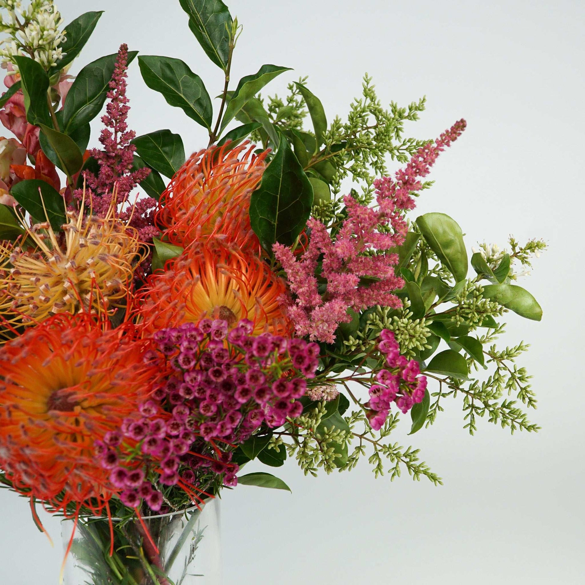 Vibrant arrangement of native blooms including pin cushions, wax flowers, and green foliage. Native Flowers