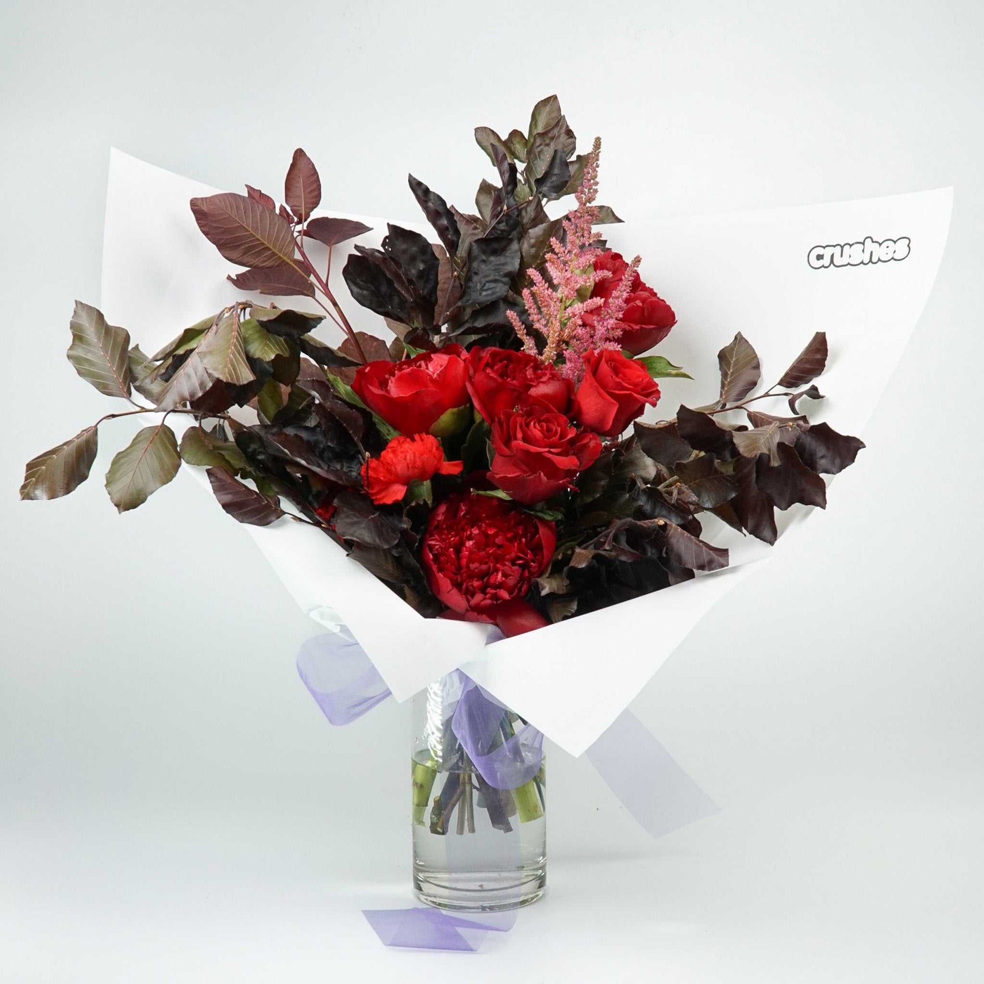 The No.05 Elegant Flowers floral arrangement with dark foliage, peonies, roses, and carnations.